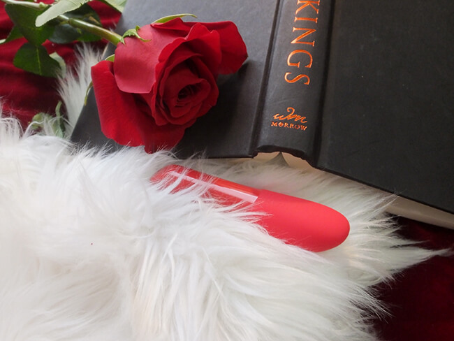 The Tango X in white faux fur, with a rose and an open black and red book